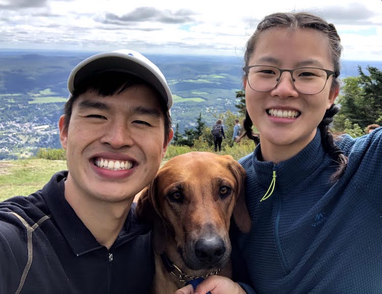 2 people with a brown dog in the middle