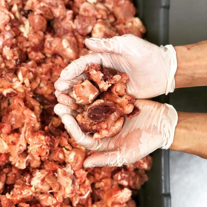 Hand holding chunky meat cuts